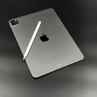Apple iPad with Apple Pencil on a sleek black surface, showcasing minimalist design.